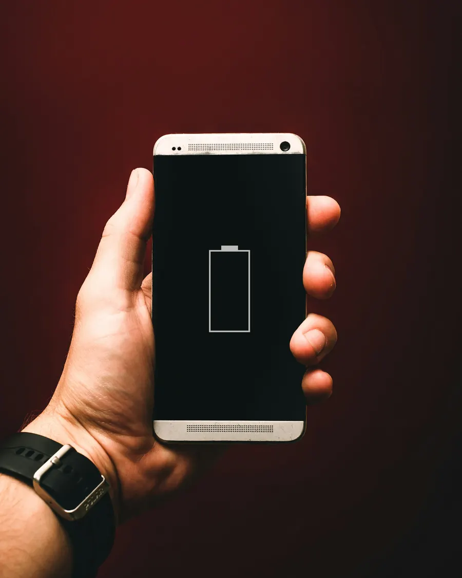Hand holding a phone showing an empty battery